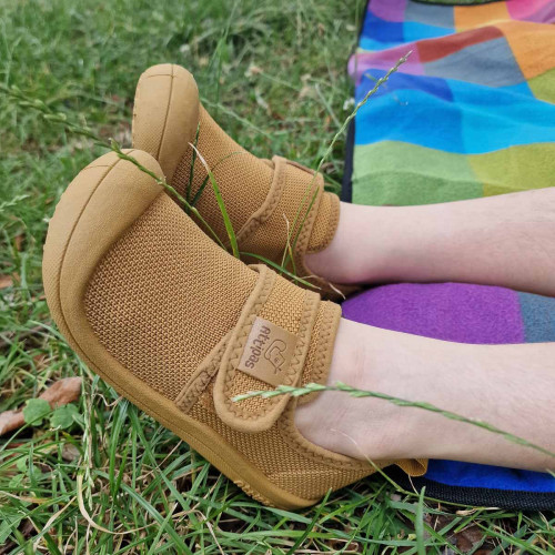 SNEAKERSY DZIECIĘCE SKIN SHOES MUSTARD|Attipas|attipas.pl|Attipas Skin Shoes Mustard - lekkie sneakersy dla dzieci w stylu barefoot
Szukasz butów, które dziecko założy bez marudzenia, a Ty będziesz mieć pewność, że stópki pracują naturalnie? Attipas Skin Shoes Mustard to wygodne, elastyczne i ultralekkie sneakersy dla dzieci, które sprawdzają się na co dzień: w domu, w przedszkolu, na spacerze i na placu zabaw. Przewiewna cholewka typu mesh pomaga utrzymać komfort nawet wtedy, gdy dziecko jest w ciągłym ruchu, a cienka podeszwa pozwala lepiej czuć podłoże - dokładnie tak, jak lubią to buty w duchu barefoot.
Dlaczego to są sneakersy barefoot?
czytaj dalej
Model Skin Shoes spełnia kluczowe cechy obuwia barefoot, czyli takiego, które nie ogranicza naturalnej pracy stopy:

Cienka i elastyczna podeszwa - stopa może swobodnie zginać się podczas chodzenia i biegania.
"Zero drop" (płaska podeszwa) - pięta nie jest sztucznie podniesiona, dzięki czemu ciężar ciała rozkłada się równomiernie.
Dopasowanie do kształtu stopy dziecka - but ma wspierać naturalny ruch, a nie ustawiać stopę na siłę.
Elastyczny zapiętek o optymalnej wysokości - stabilizuje delikatnie, ale nie usztywnia jak klasyczne, ciężkie buty.

Efekt? Dziecko może poruszać się naturalnie, pewnie i wygodnie - bez człapiących kroków, typowych dla sztywnego obuwia.
1) Lekkość, którą dziecko lubi
To typ buta, który nie ciąży na nodze. Dzieci często same po niego sięgają, bo po prostu jest wygodny.
2) Elastyczność
Bieganie, kucanie, wspinanie się, skakanie - nic nie blokuje stopy. Sneakersy pracują razem z dzieckiem.
3) Przewiewna siateczka mesh
Cholewka wspiera cyrkulację powietrza, co pomaga utrzymać komfort w cieplejsze dni i podczas intensywnej zabawy.
4) Uniwersalne zastosowanie

jako buty na zmianę do przedszkola i szkoły
na spacery i codzienne wyjścia
do zabawy na zewnątrz i w domu

Kolor Mustard - styl, który pasuje do wszystkiego
Musztardowy odcień jest ciepły, nowoczesny i praktyczny: świetnie wygląda zarówno ze sportowymi dresami, jak i z jeansami czy sukienką. To taki kolor, który dodaje charakteru i świetnie wygląda na co dzień.
Łatwa pielęgnacja
Duży plus dla zabieganych rodziców: buty można prać w pralce, więc po sezonie (albo po przygodach na placu zabaw) łatwo przywrócić im świeżość.
Dla kogo będą najlepsze?
Attipas Skin Shoes Mustard to dobry wybór, jeśli szukasz sneakersów dla dzieci, które:

są miękkie i elastyczne,
wspierają naturalny rozwój stóp w duchu butów barefoot dla dzieci,
sprawdzają się jako buty na zmianę i do codziennej aktywności,
są wygodne zarówno dla maluchów, jak i starszaków w ciągłym biegu.

     