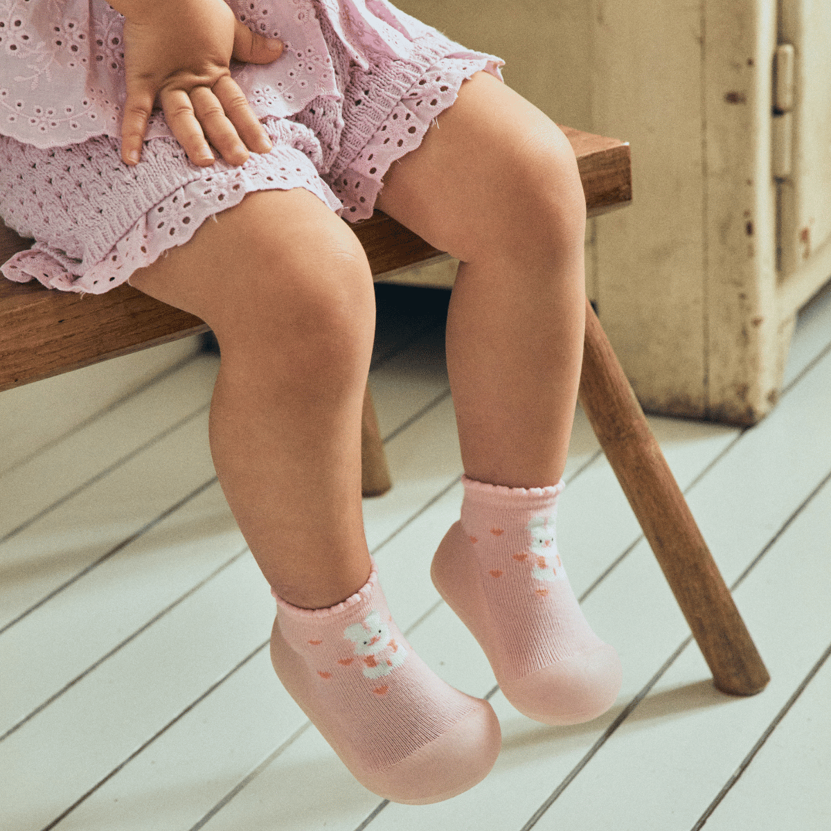 Rożowe, skarpetkowe buciki barefoot dla dziewczynki od marki Attipas, z printem króliczka i z serduszkami