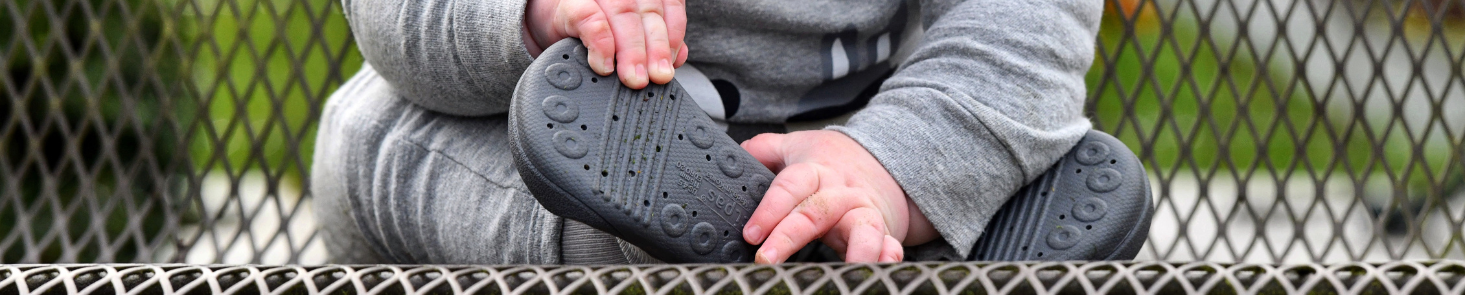 Pierwsze Buty Dla Dziecka Attipas z cienką, czarną podeszwą z otworkami i skarpetkową cholewką w kolorze szarym